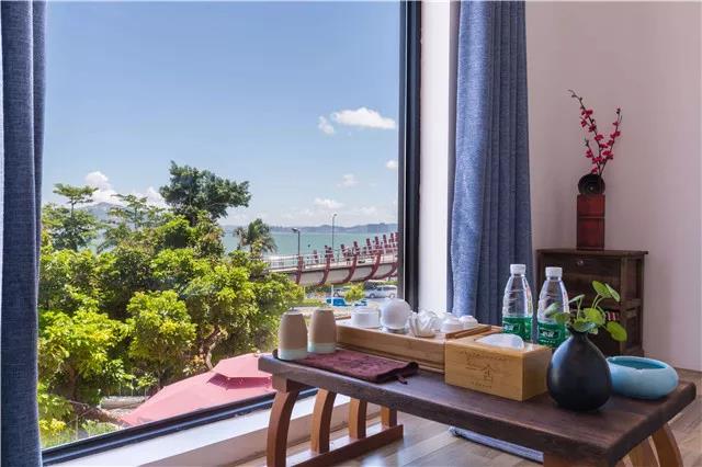 搭配原色木制家具,极为素雅,干净明澈,敞亮的落地窗设计让客人随时都